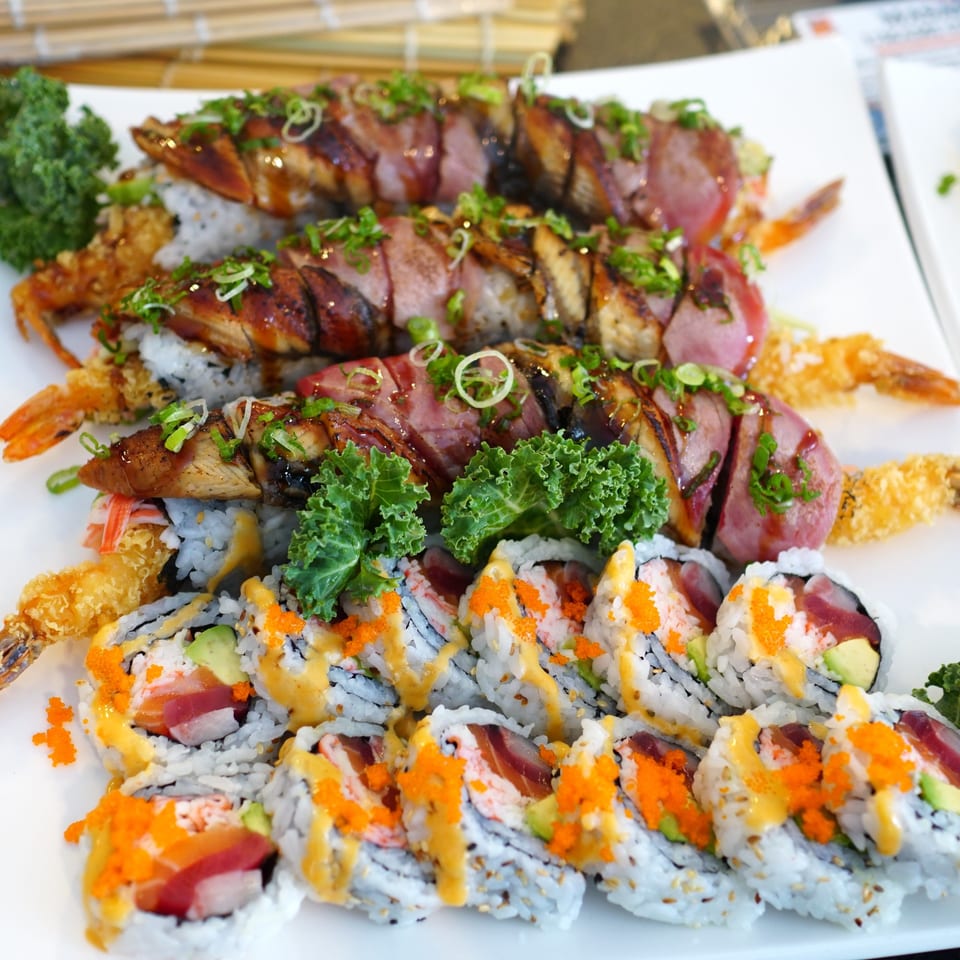 Platter of Tsunami Sushi rolls with various toppings, including eel, tuna, and tempura shrimp.